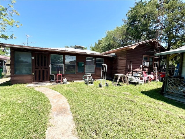 rear view of property with a lawn