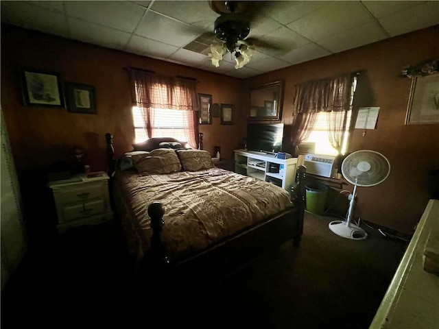 bedroom featuring a paneled ceiling, ceiling fan, and cooling unit