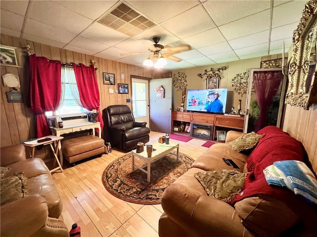 living room featuring ceiling fan, wood walls, cooling unit, a paneled ceiling, and hardwood / wood-style flooring