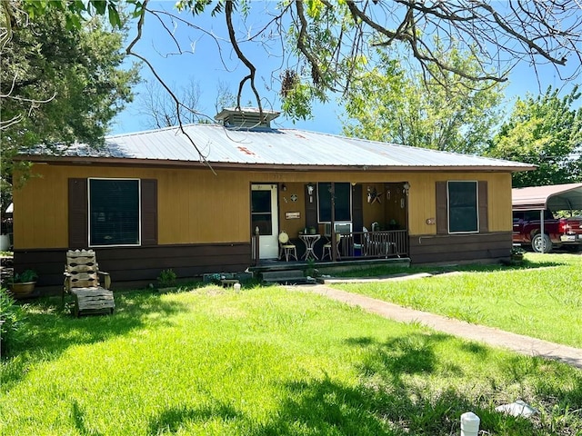 rear view of property featuring a lawn