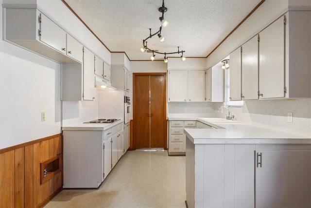 kitchen featuring a textured ceiling, white cabinetry, and sink