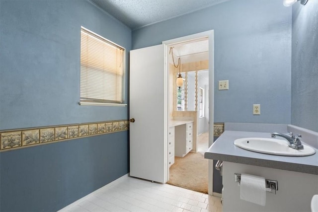 bathroom with tile patterned flooring, sink, and a textured ceiling