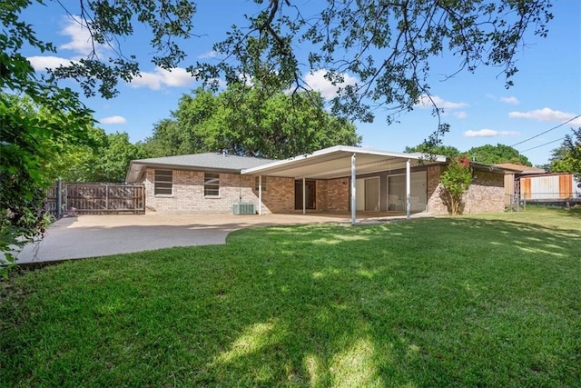 rear view of property with a yard and a patio area