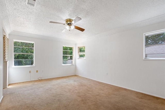 carpeted spare room with a textured ceiling and ceiling fan