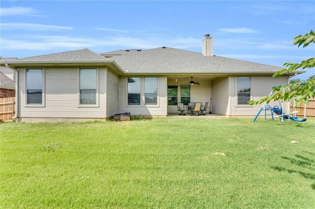 rear view of property featuring ceiling fan, a yard, and a patio