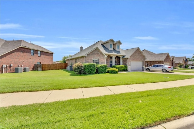 view of front of house featuring central AC unit, a garage, and a front lawn