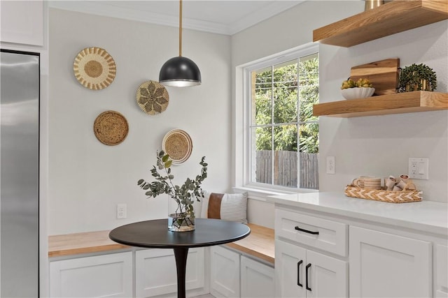 interior space with stainless steel built in fridge and crown molding