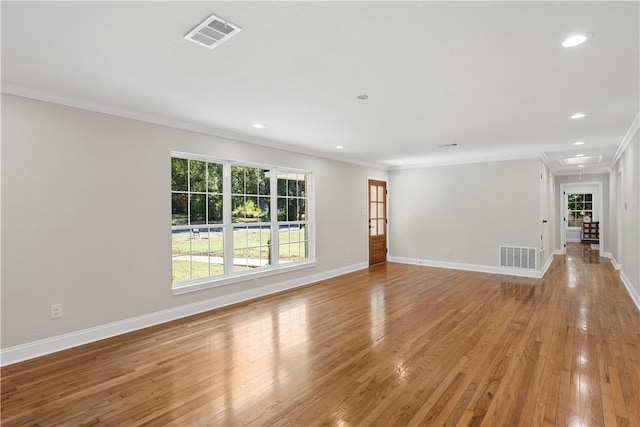 empty room with light hardwood / wood-style floors and ornamental molding