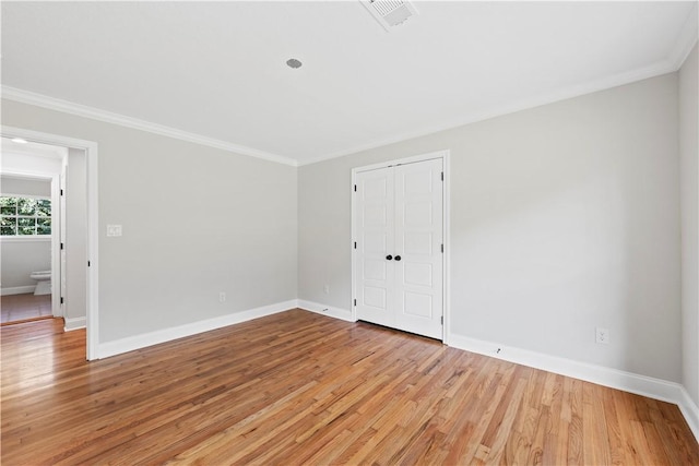 unfurnished room with light wood-type flooring and crown molding