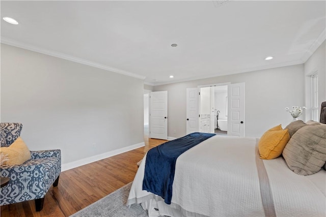 bedroom featuring crown molding, ensuite bathroom, and light hardwood / wood-style floors