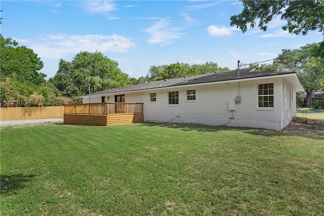 back of house featuring a lawn and a wooden deck