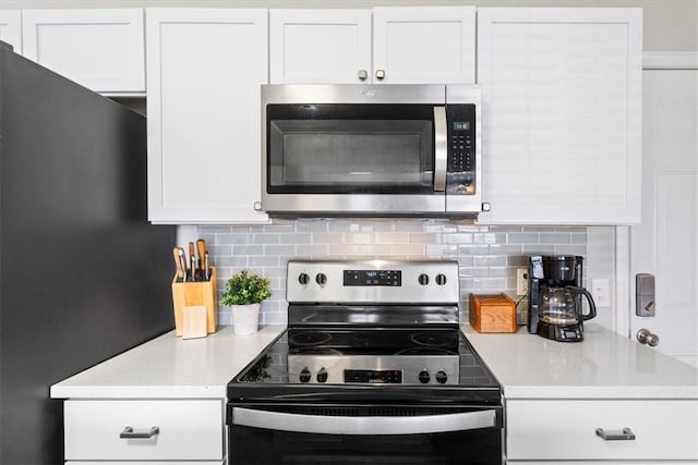 kitchen featuring stainless steel microwave, white cabinetry, electric range, and decorative backsplash