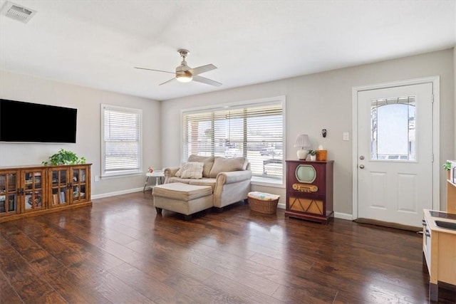 living area with a ceiling fan, dark wood-type flooring, baseboards, and visible vents