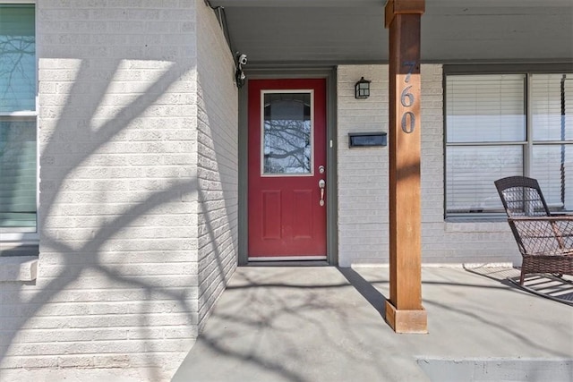 view of exterior entry featuring brick siding