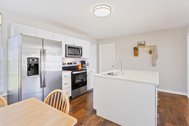 kitchen with a sink, dark wood-type flooring, a center island with sink, and stainless steel appliances