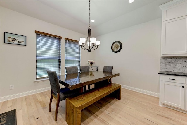 dining space with light wood-type flooring and a chandelier