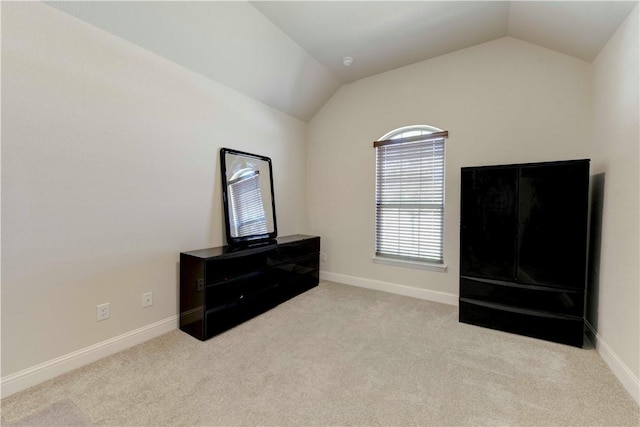 misc room featuring lofted ceiling and light carpet