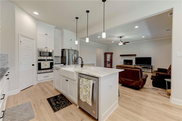 kitchen featuring ceiling fan, an island with sink, light hardwood / wood-style floors, white cabinetry, and stainless steel appliances