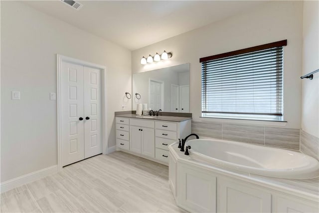 bathroom featuring a bathing tub, vanity, and wood-type flooring