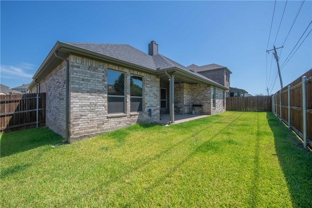 back of house featuring a lawn and a patio area