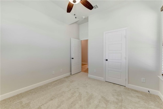 unfurnished bedroom featuring light carpet and ceiling fan