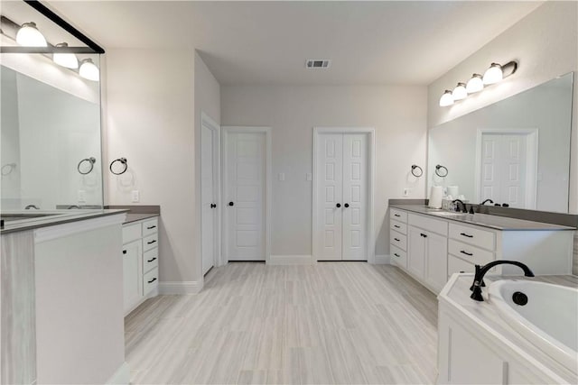 bathroom featuring hardwood / wood-style floors, vanity, and a bathtub