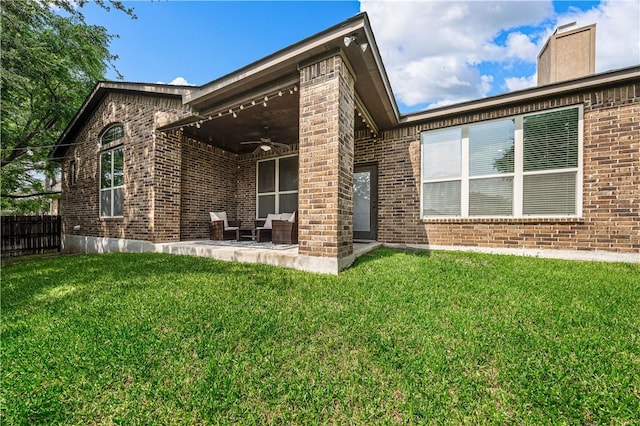 back of property featuring ceiling fan, a patio area, and a lawn