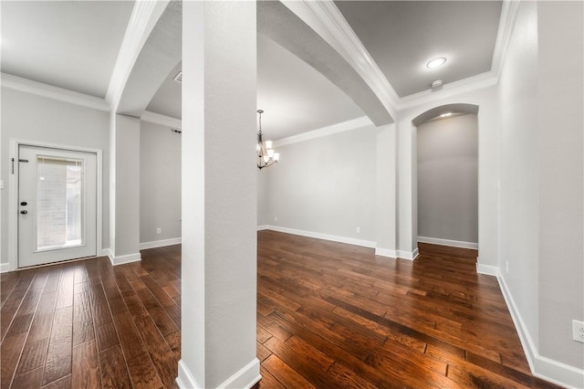 foyer with a notable chandelier, dark hardwood / wood-style floors, and ornamental molding