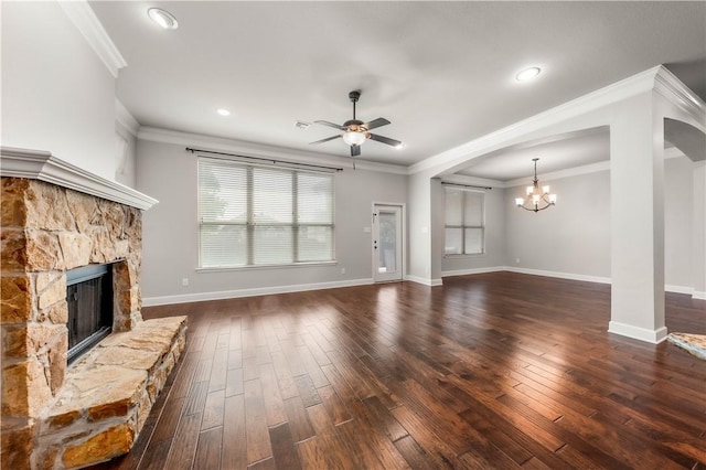 unfurnished living room with a fireplace, dark wood-type flooring, ceiling fan with notable chandelier, and ornamental molding