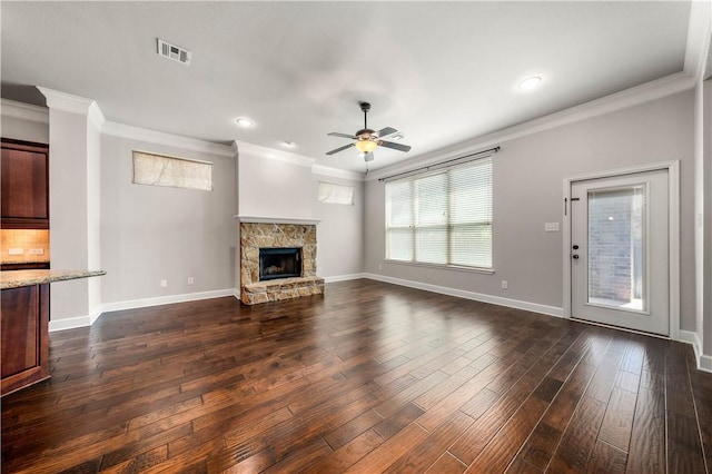 unfurnished living room with ceiling fan, ornamental molding, a fireplace, and dark wood-type flooring