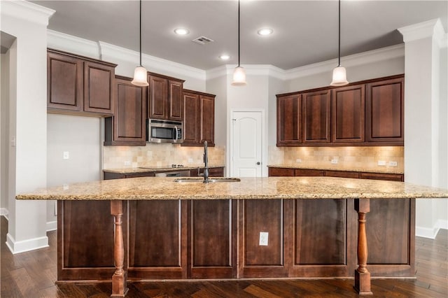 kitchen featuring decorative light fixtures, dark hardwood / wood-style floors, light stone counters, and sink