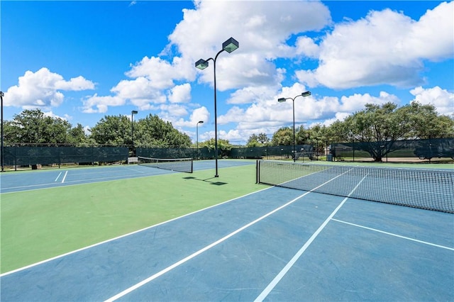 view of tennis court featuring basketball hoop