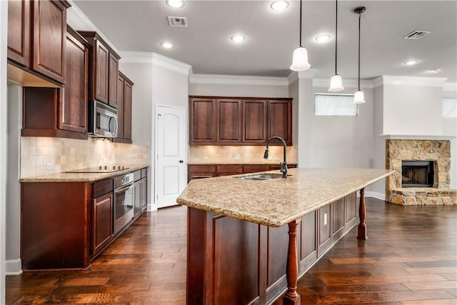 kitchen featuring sink, dark wood-type flooring, pendant lighting, and appliances with stainless steel finishes