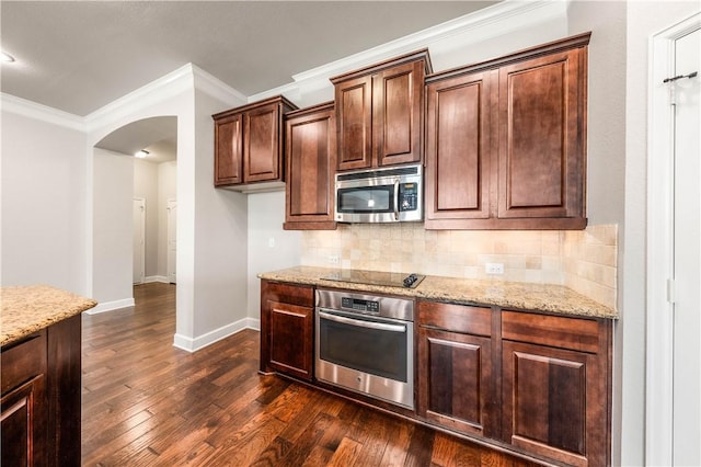 kitchen featuring light stone countertops, dark wood-type flooring, tasteful backsplash, appliances with stainless steel finishes, and ornamental molding