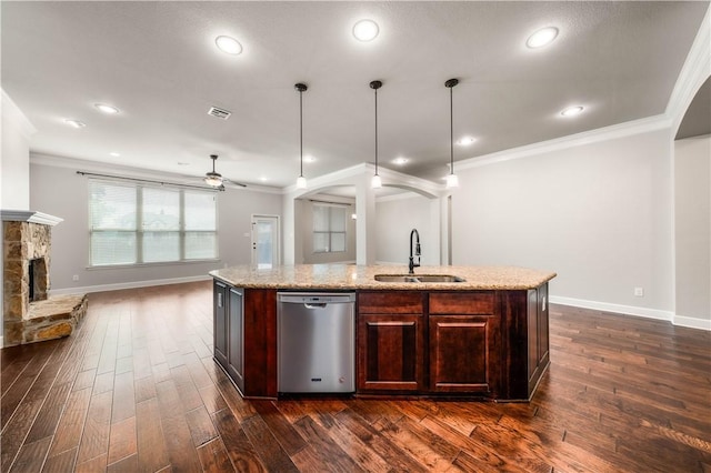 kitchen with ceiling fan, sink, hanging light fixtures, stainless steel dishwasher, and an island with sink