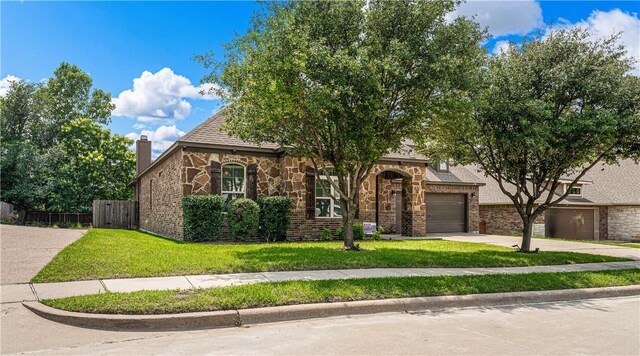 view of front of home with a front yard and a garage