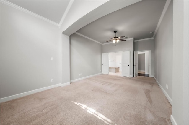 unfurnished room with ceiling fan, light colored carpet, and crown molding