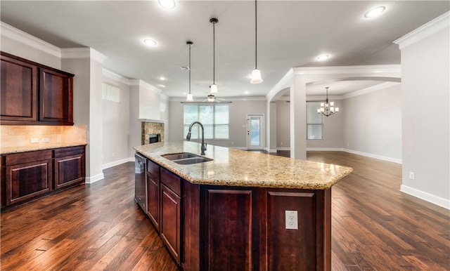 kitchen featuring a center island with sink, stainless steel dishwasher, dark wood-type flooring, and sink