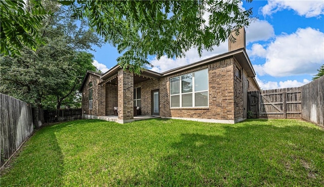 rear view of house featuring a yard