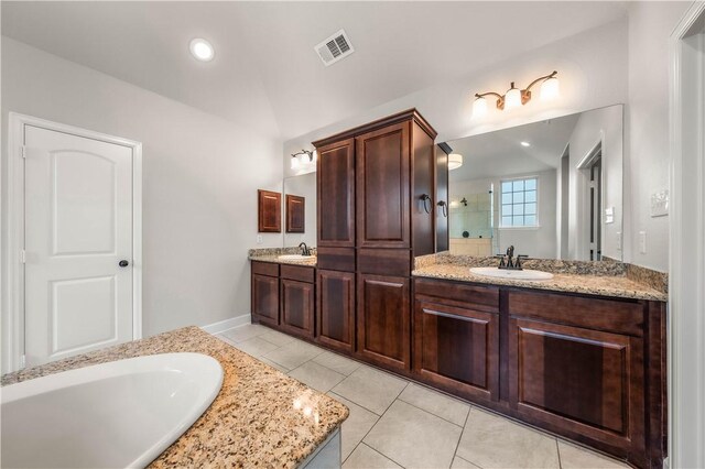 bathroom featuring tile patterned flooring, vanity, a shower, and lofted ceiling