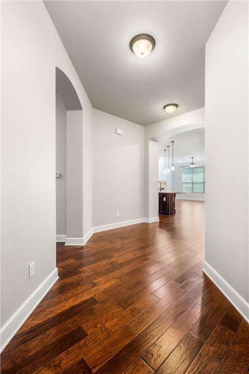 empty room featuring dark hardwood / wood-style flooring and ceiling fan