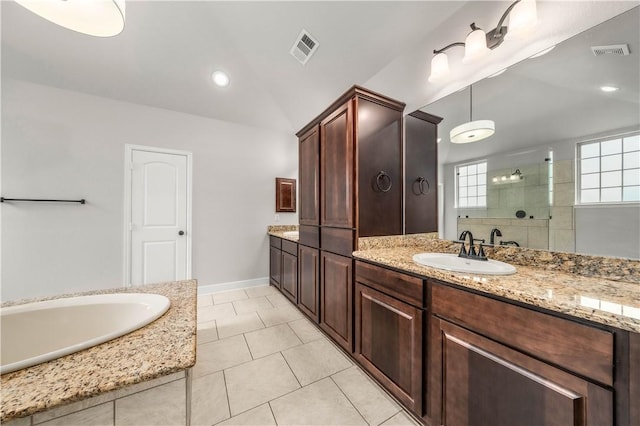 bathroom with tiled shower, vanity, and tile patterned flooring