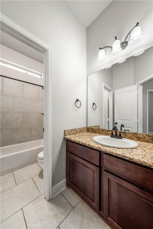 full bathroom featuring tile patterned floors, vanity, toilet, and tiled shower / bath combo