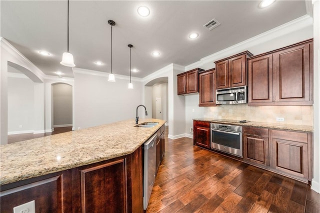 kitchen featuring light stone countertops, stainless steel appliances, dark wood-type flooring, sink, and pendant lighting