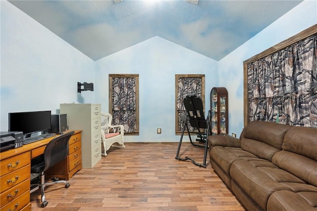 office area with light hardwood / wood-style floors and vaulted ceiling