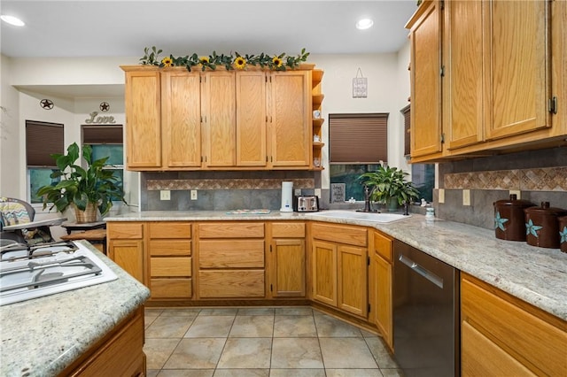 kitchen with backsplash, light stone counters, sink, light tile patterned floors, and dishwasher