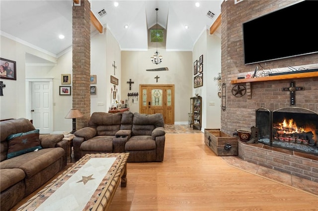 living room with light hardwood / wood-style floors, high vaulted ceiling, and ornamental molding