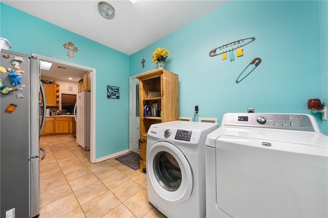 laundry room featuring independent washer and dryer and light tile patterned flooring