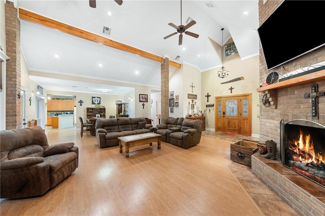 living room with a fireplace, light wood-type flooring, high vaulted ceiling, and crown molding