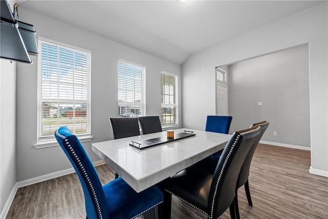 dining room featuring hardwood / wood-style flooring and lofted ceiling